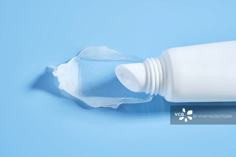蓝色背景上的白色润唇膏管，质地细腻图片素材