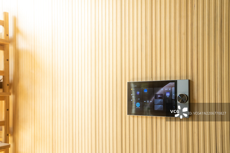 现代智能家居控制设备安装在木质纹理的室内墙壁上图片素材