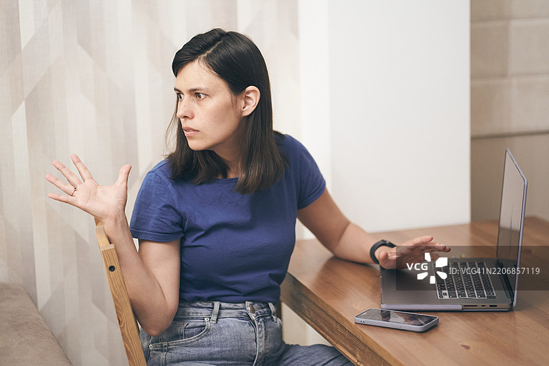 女人因为噪音无法工作而感到生气，并请求将声音调低。图片素材