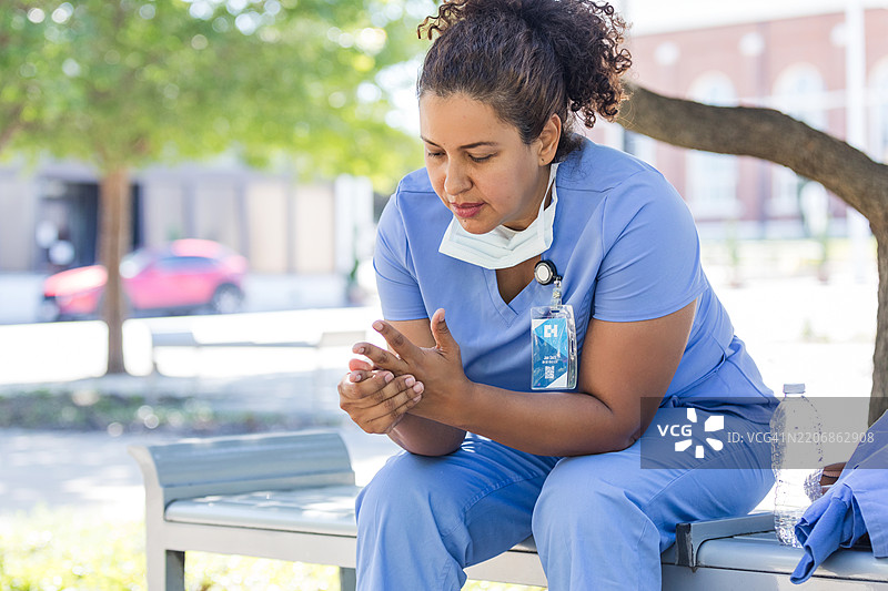 沉思的护士穿着工作服在户外休息图片素材
