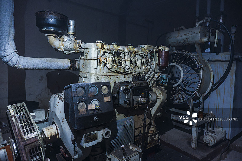 老旧工业发动机展示了昏暗车间环境中的机械工艺。图片素材