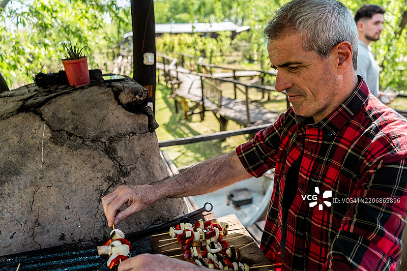 阿根廷蒂格雷的老年男子在烧烤图片素材