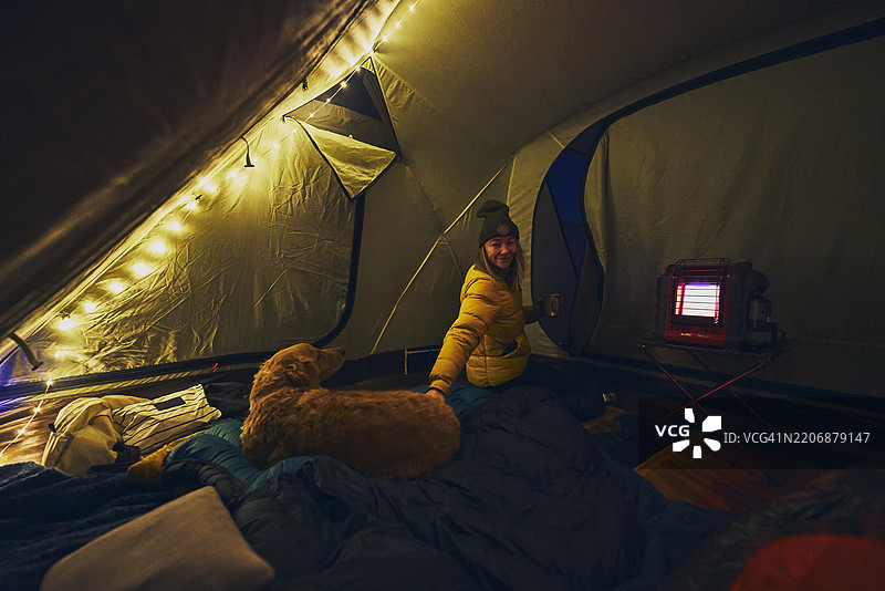女人和狗在帐篷里露营图片素材