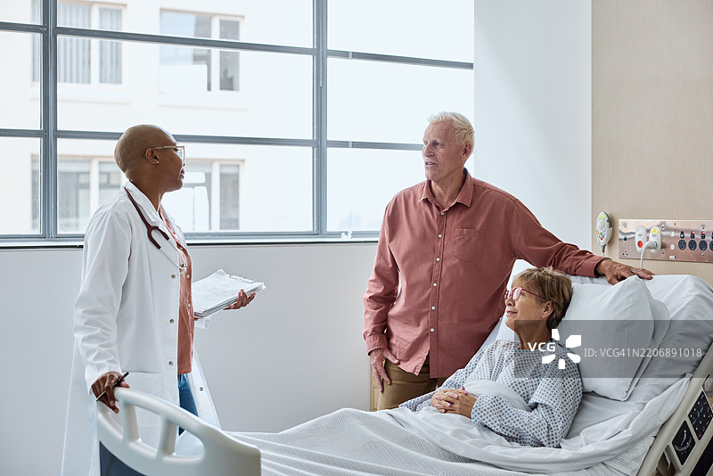 秃头医生在医院与一对老年夫妇交谈图片素材