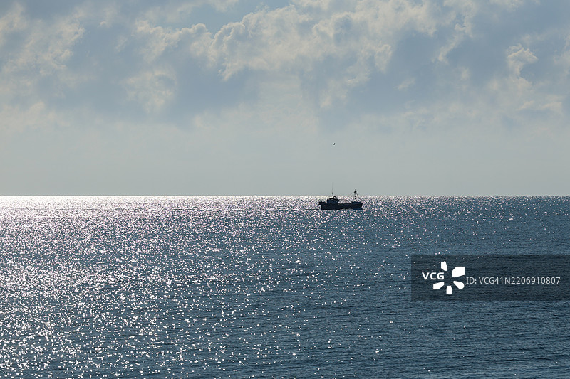 在闪耀的海面上的渔船图片素材