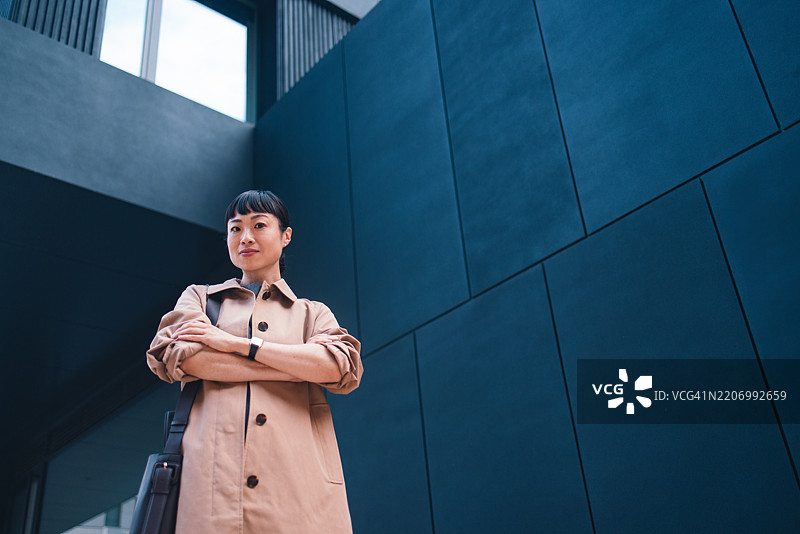 自信的女商人在现代建筑附近的城市街道上站立图片素材