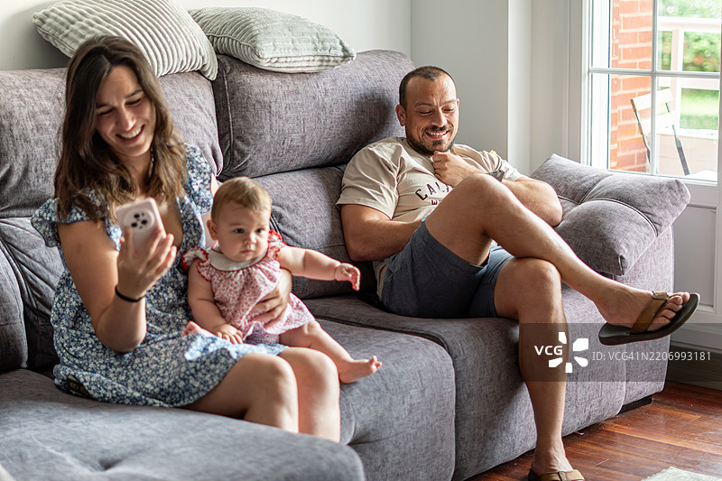 一家人坐在沙发上。图片素材