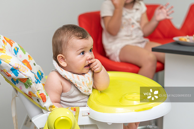一个坐在高脚椅上的婴儿图片素材
