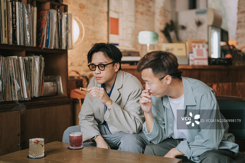 亚洲年轻男性在咖啡馆闲逛，享受周末时光图片素材