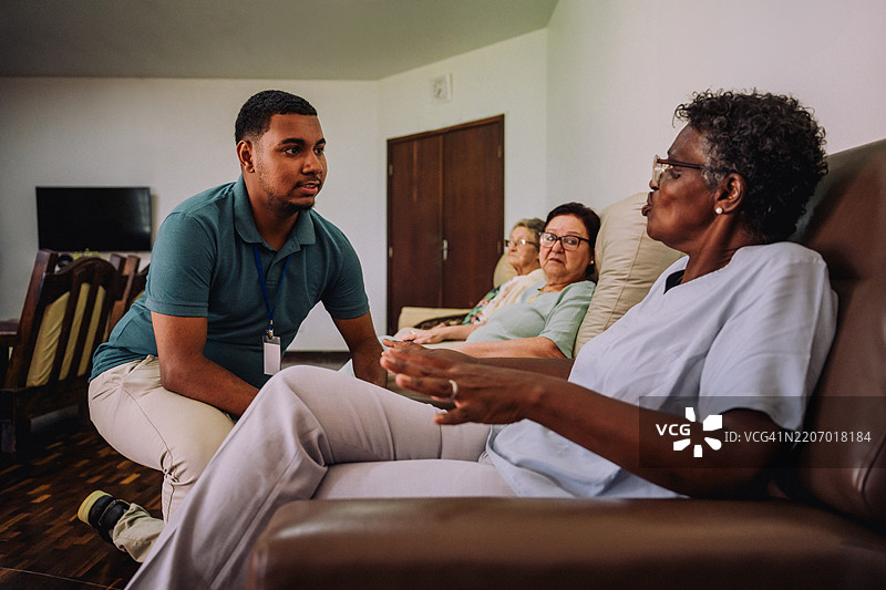 年轻志愿者在养老院与老年女人交谈图片素材