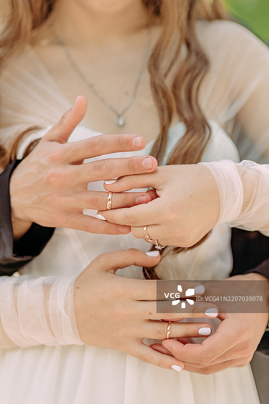 新郎新娘展示婚戒，两位恋人的手图片素材