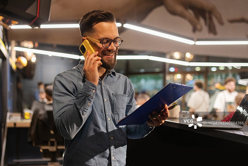 在繁忙的理发店中多任务处理的企业家图片素材