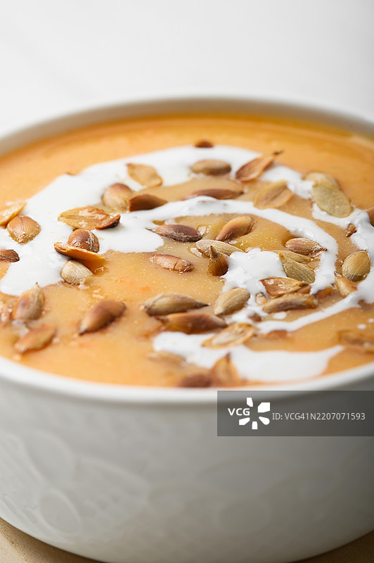 温暖秋季环境中的奶油南瓜汤配烤种子图片素材