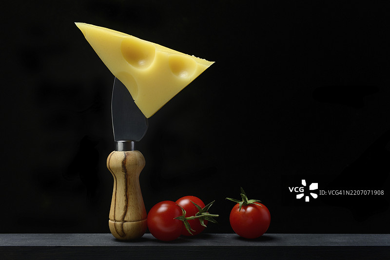 一块瑞士埃门塔尔奶酪放在奶酪刀上图片素材