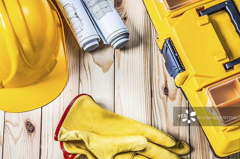 手套、蓝图、工具箱和头盔放在木头上图片素材
