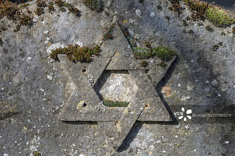 德国巴伐利亚州下法兰肯地区维尔茨堡，西门子街2号，1882年奉献的以色列公墓上的风化大卫星墓碑图片素材