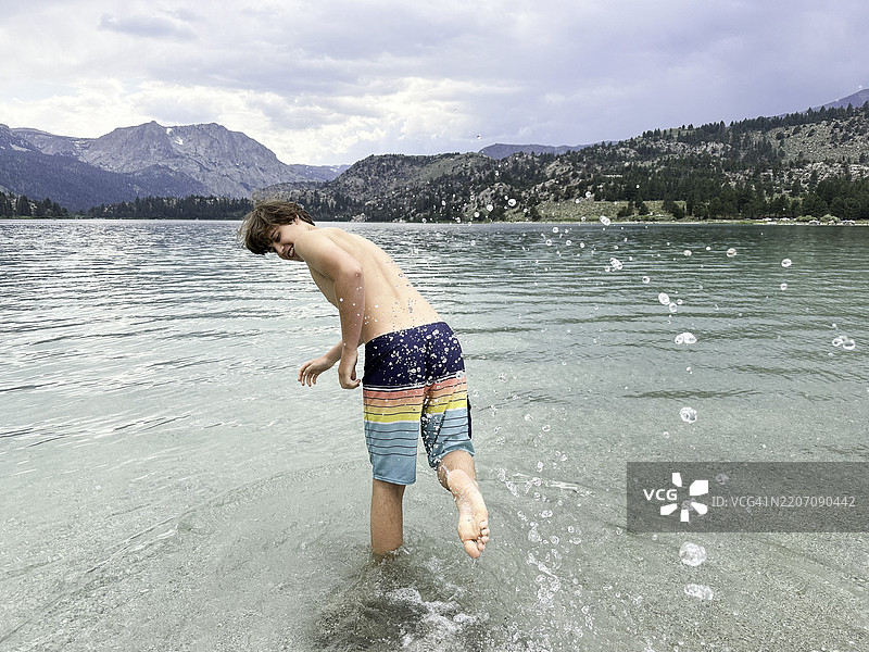 青少年在寒冷的山湖中玩耍和游泳图片素材