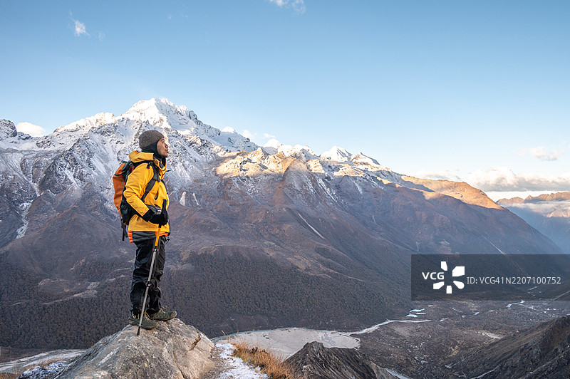 游客站在岩石上，欣赏尼泊尔朗塘谷的美丽景色。图片素材