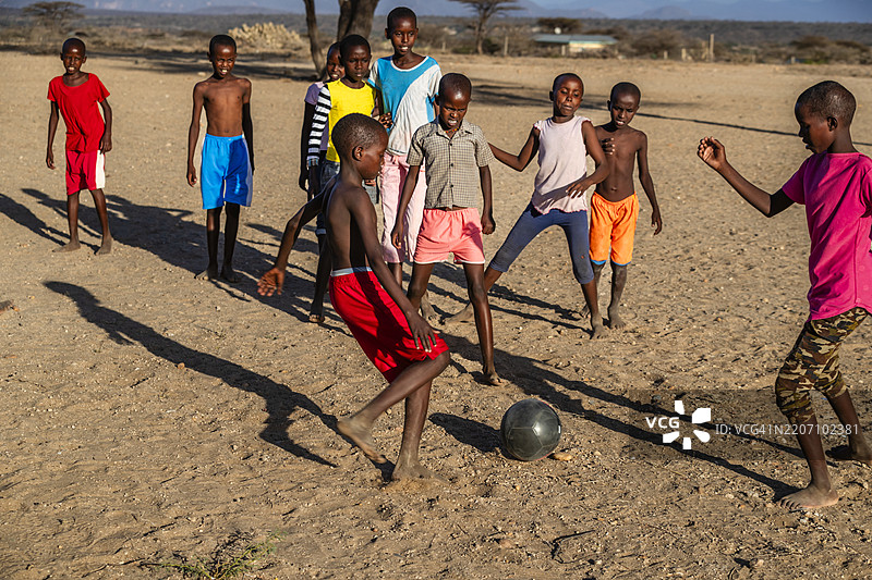 东非肯尼亚北部村庄里的非洲儿童在踢足球图片素材