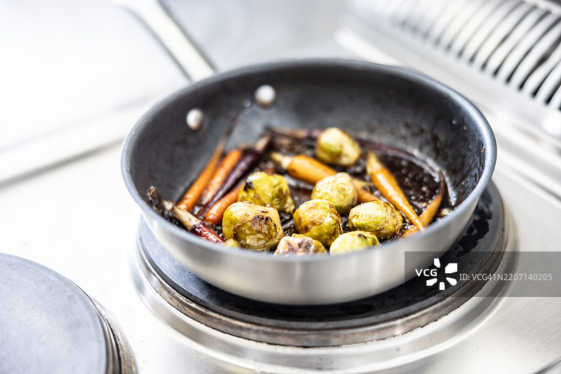 准备好的锅中盛放着布鲁塞尔芽菜和胡萝卜作为配菜图片素材