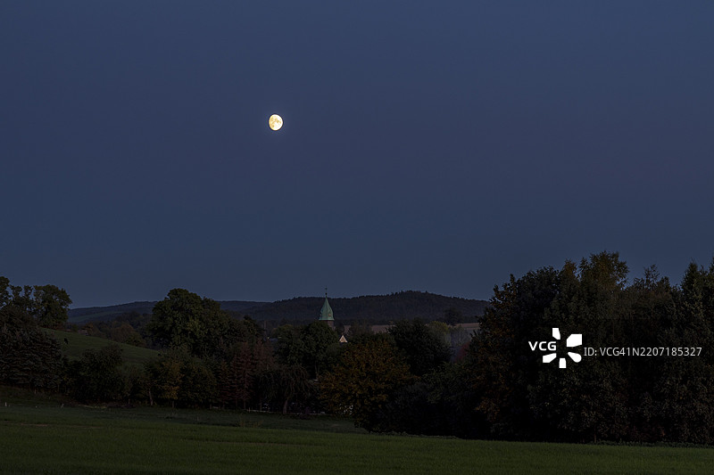 莱根沃尔姆斯多夫村的月亮与村庄教堂，斯托尔彭，萨克森，德国，欧洲图片素材