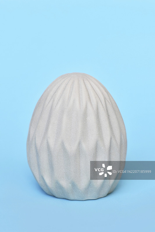 蓝色背景上的单个蜂窝图案复活节彩蛋图片素材