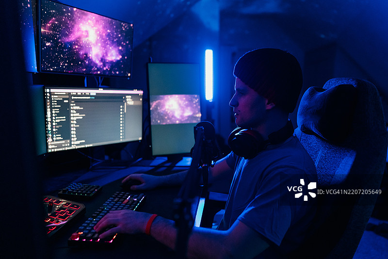 专注的软件开发人员在未来派办公室夜间编写代码图片素材