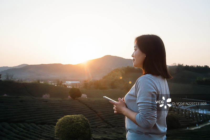 亚洲女性在日落时望向远方图片素材