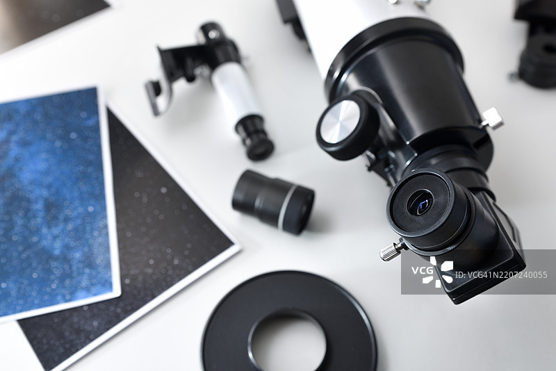 白色桌子上放着带有照片的望远镜目镜细节图片素材