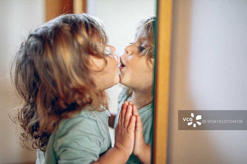 小女孩亲吻镜子里的自己图片素材