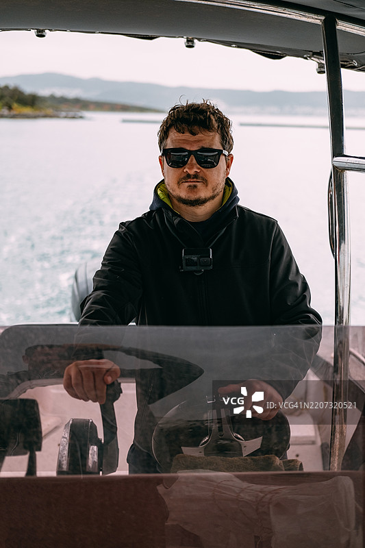 年轻男子驾驶一艘船图片素材