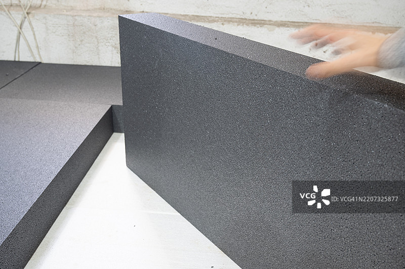 一个人在房子里使用泡沫塑料进行隔热。图片素材