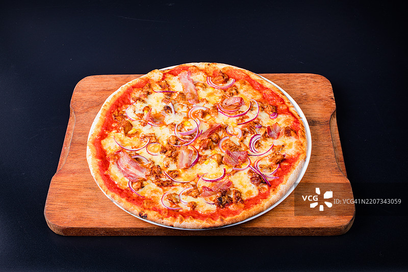 黑色背景下切菜板上的披萨俯视图图片素材