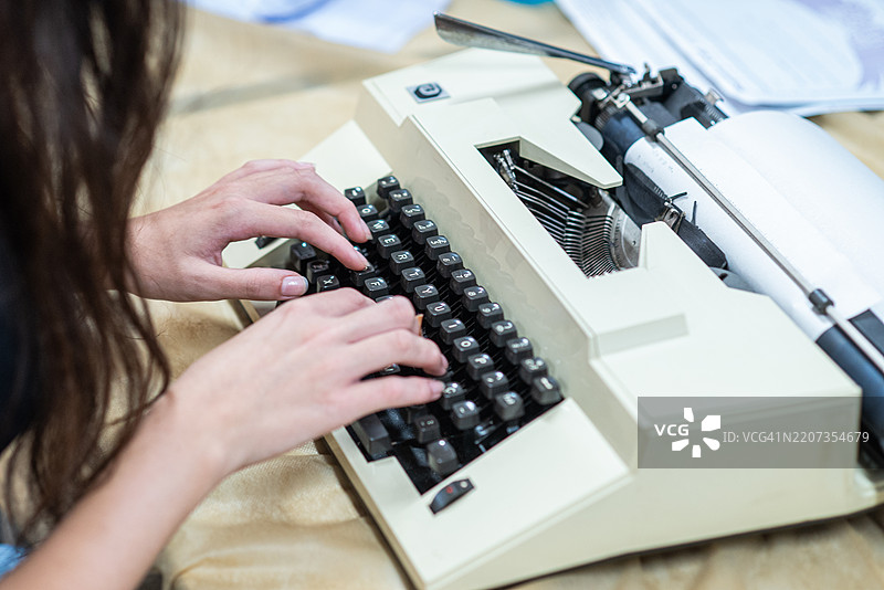 一个人在复古打字机上打字图片素材