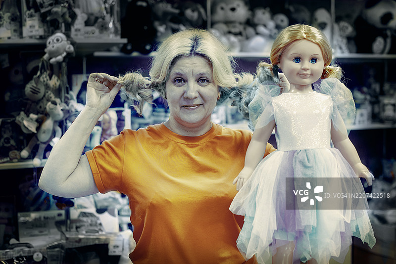 一位女性在满是毛绒玩具的架子前抱着一个玩偶。图片素材