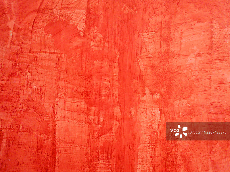 明亮红色油漆在混凝土墙上的特写层次。粗糙的纹理。自然光和色彩。葡萄牙，波尔图。图片素材