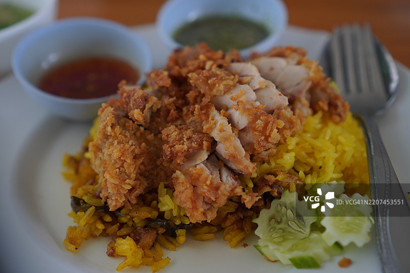 鸡肉香饭，黄色的传统印度菜，由米饭和腌制香料的鸡肉以及绿色酱汁组成图片素材