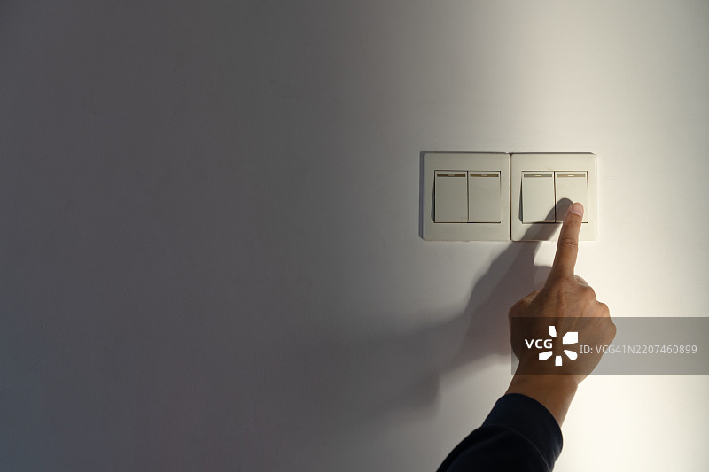 手按墙上的灯开关图片素材