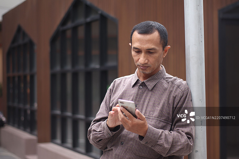 一名男子在家中使用互联网。图片素材