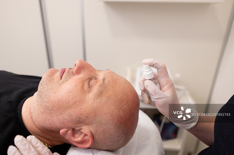 成熟男性正在接受美容师的面部护理图片素材