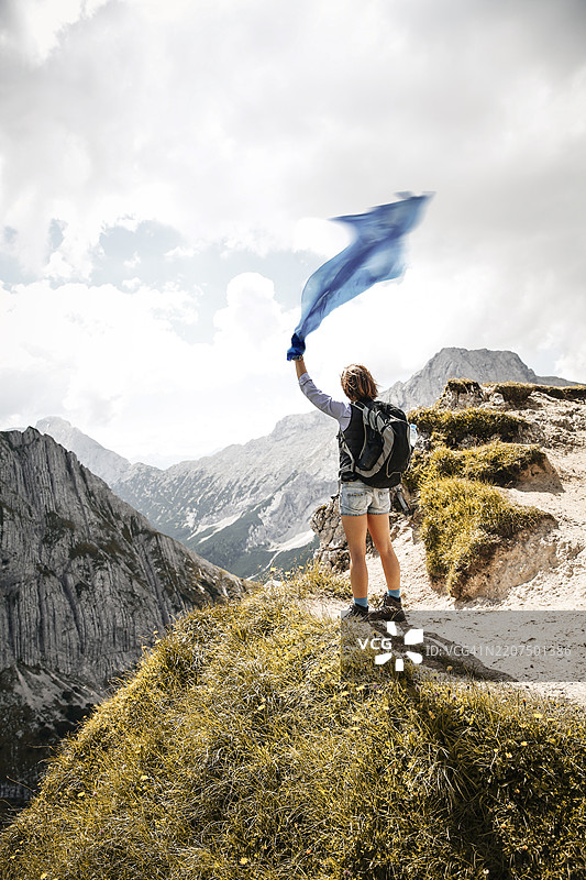 奥地利，蒂罗尔，一名女性在山中徒步旅行，手持布料图片素材