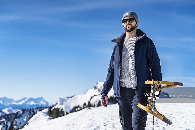 德国，巴伐利亚，布劳内克，冬季山中一个人背着雪橇图片素材