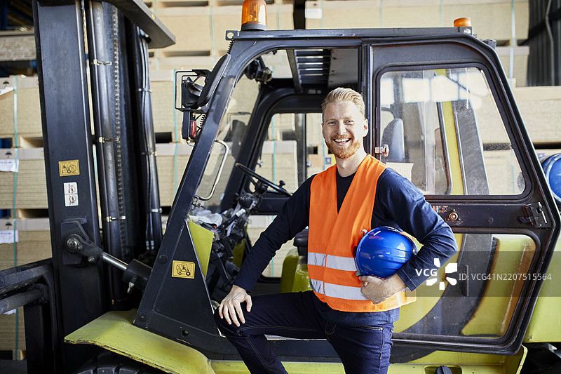 工厂中快乐的叉车工人肖像图片素材