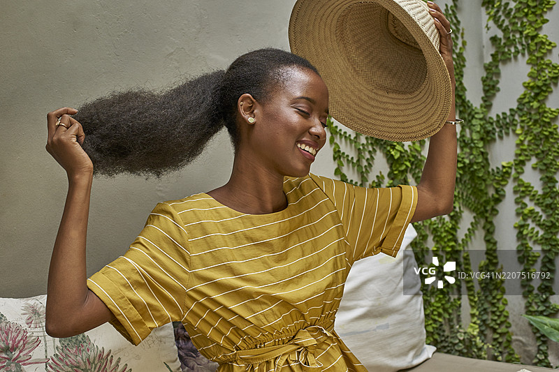 快乐的长发女性戴上传统帽子图片素材