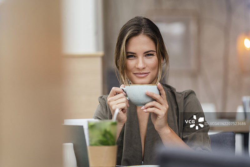 年轻女商人在咖啡馆里喝咖啡图片素材