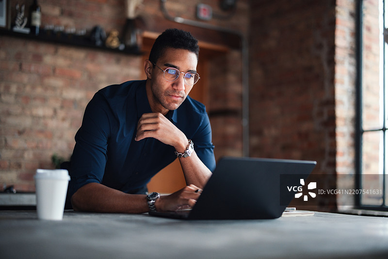 专注的专业人士在现代砖砌办公室空间中使用笔记本电脑图片素材
