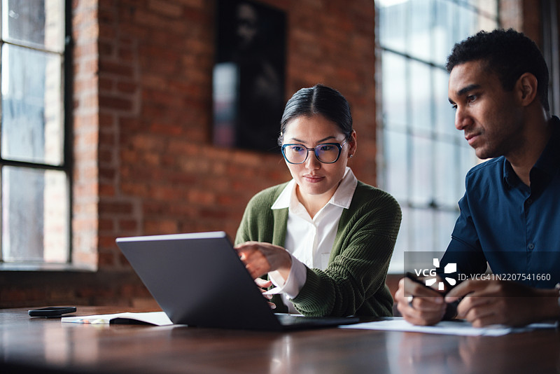 同事们在自然采光的现代办公室空间中合作图片素材