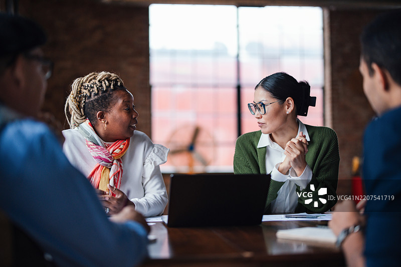 多元化团队在明亮的办公室环境中进行专业讨论图片素材