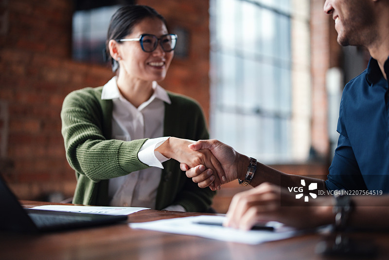现代办公室环境中的专业握手，象征着商业协议的达成图片素材