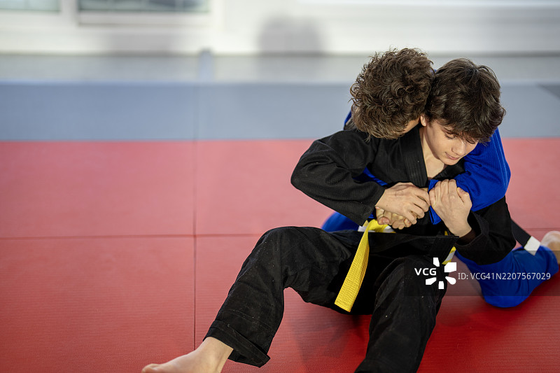 两个年轻男孩在训练垫上练习武术图片素材